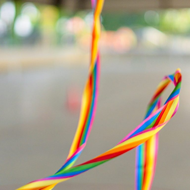 Tanz AG Bunte, spiralförmige Bänder in den Farben des Regenbogens, die im Wind wehen.