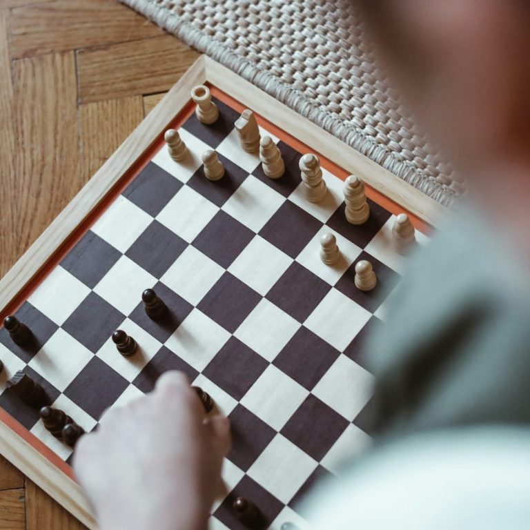 Schach AG Eine Person spielt Schach; die Figuren stehen auf einem Schachbrett.